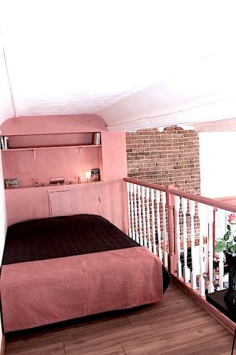 - une chambre avec un lit rose sur un balcon dans l'établissement Le Duplex du Mole, à Sète