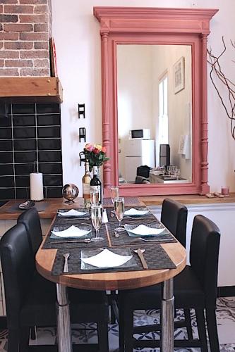 - une table avec des chaises et un miroir dans la chambre dans l'établissement Le Duplex du Mole, à Sète