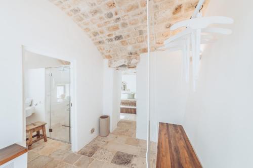 a bathroom with a glass shower and a wooden table at Borgo Canonica in Cisternino