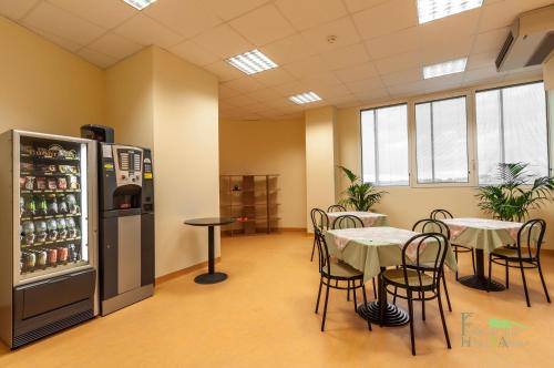 an empty restaurant with tables and a refrigerator at Foresteria Sant'Anna in Ferrara