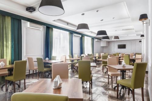 un comedor con mesas, sillas y ventanas en Hotel Sokol, en Moscú