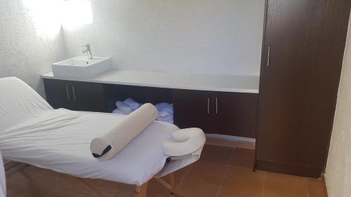 a bathroom with a bed with a sink and a sink at Sunflower Guesthouse in Vanderbijlpark