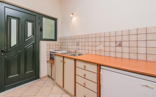 a kitchen with a green door and a sink at Giovanna Studios in Keri