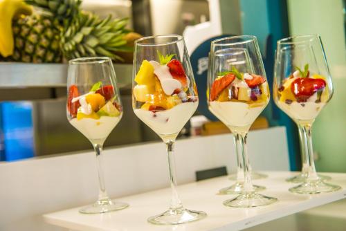 four glasses of white wine with fruit in them at Infinity Blue Boutique Hotel & Spa - Adults Only in Hersonissos