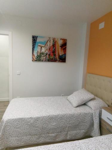 a bedroom with two beds and a painting on the wall at VIVE CENTRO ASTORGA in Astorga