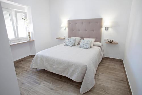 阿爾戈多納萊斯的住宿－EL PALOMAR，白色卧室配有一张带两个枕头的大床