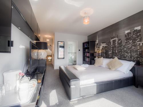 a bedroom with a large bed with a black headboard at TLC Exmouth Bed and Breakfast in Exmouth