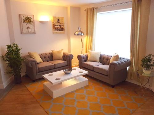 a living room with two couches and a coffee table at 3 Bed Luxury Town Center Apartment with 50 inch 4K TV (Netflix & NowTV Ent. Pass) in Northampton