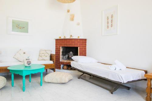 a living room with two beds and a fireplace at Salla Chiotis in Karpathos