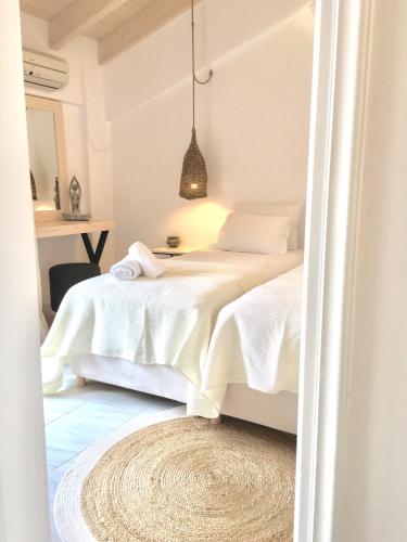 a bedroom with a bed with white sheets at Alkestis Studios in Lixouri