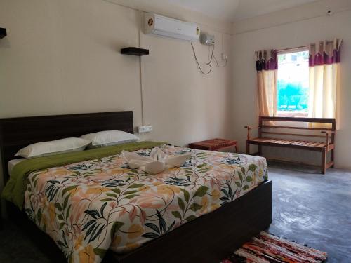 a bedroom with a bed with a flowered comforter at Havelock Farms Resort in Havelock Island