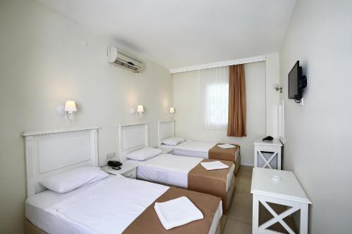 Un pat sau paturi într-o cameră la Summer Garden Suites Beach Hotel