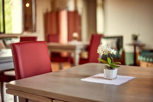 a wooden table with a vase with flowers on it at Il Mastio di Spedaletto in Pienza
