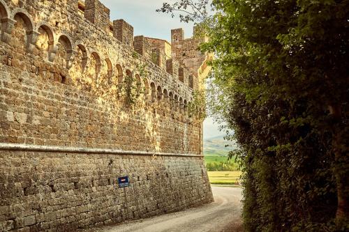 an alley in the side of a brick wall at Il Mastio di Spedaletto in Pienza