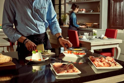 a man preparing food on a table in a restaurant at Il Mastio di Spedaletto in Pienza