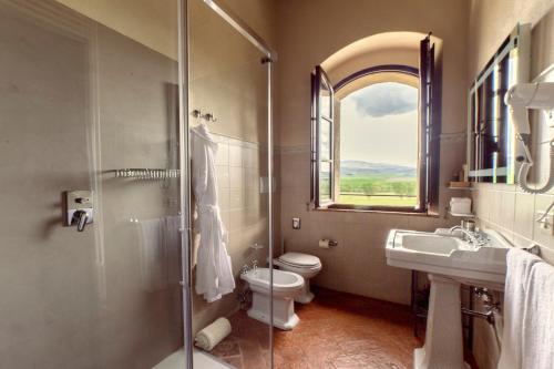 a bathroom with a shower and a toilet and a sink at Il Mastio di Spedaletto in Pienza
