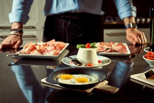 a table with two plates of eggs and meat at Il Mastio di Spedaletto in Pienza