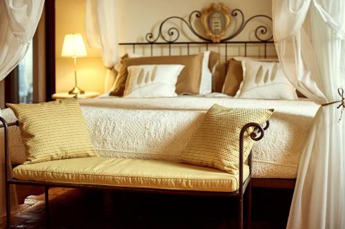 a bedroom with a large bed with a couch at Il Mastio di Spedaletto in Pienza