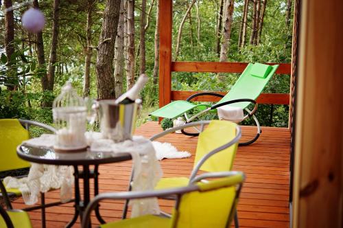 un patio con mesa y sillas en una terraza en Ośrodek Delfin, en Ślesin