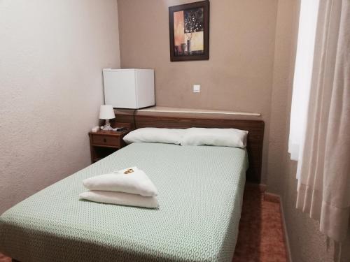 a room with two beds with white towels on them at Pensión Fortea in Zaragoza