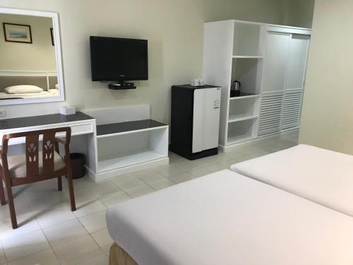a room with two beds and a tv and a mirror at Star 3 Hotel and Residence in Rayong