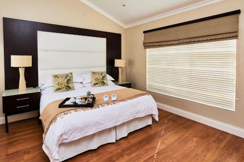 a bedroom with a large bed and a large window at Forest Manor Boutique Guesthouse in Durban