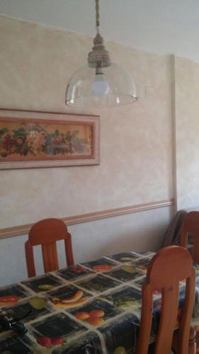 comedor con mesa, 2 sillas y lámpara en BIESCAS PIRINEOS, en Biescas
