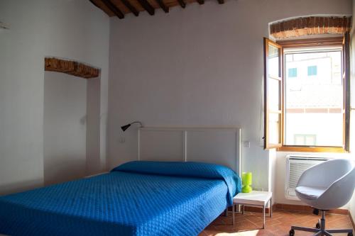 ポルトフェッラーイオにあるPepe Nero by HelloElbaのベッドルーム(青いベッド1台、白い椅子付)
