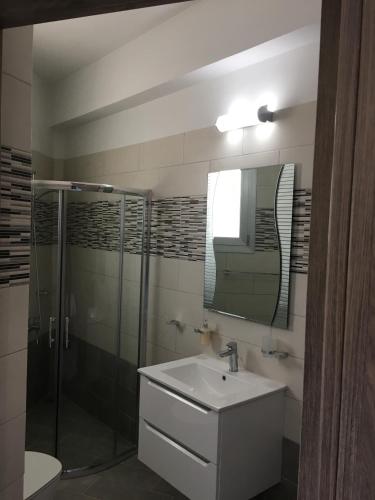 a bathroom with a sink and a shower and a mirror at Elite Sea View Villa in Pomos