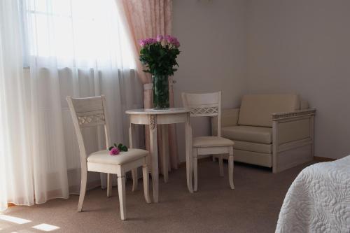 a room with a table and chairs and a vase with flowers at Hotel Kresowiak in Siemiatycze