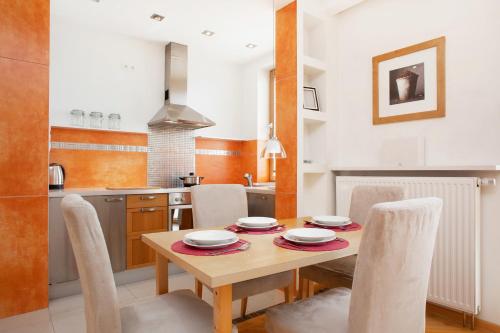 ワルシャワにあるApartment Warsaw Wilanowska by Noclegi Rentersの木製のテーブルと椅子が置かれたキッチン