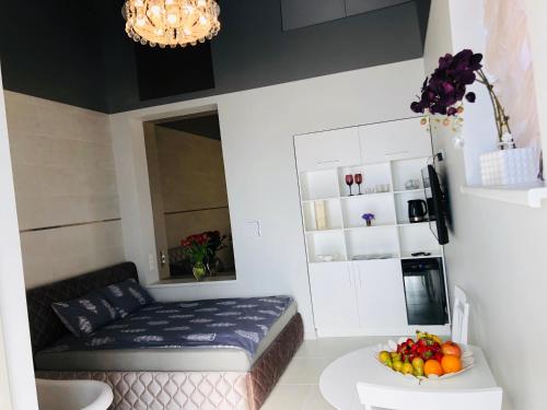 a room with a bed and a bowl of fruit on a table at Romeo VIP apartamentai in Panevėžys