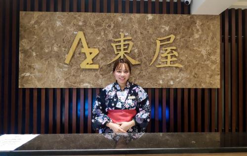 a woman standing at a counter in front of a sign at Azumaya Hotel Hai Phong in Hai Phong