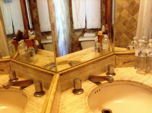 a bathroom with two sinks and a large mirror at Posada de la Mision, Hotel Museo y Jardin in Taxco de Alarcón