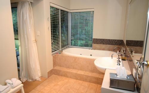 a bathroom with a tub and a sink at Margaret River Bed & Breakfast in Margaret River Town