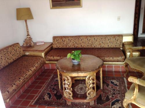 a living room with a couch and a table at Posada de la Mision, Hotel Museo y Jardin in Taxco de Alarcón