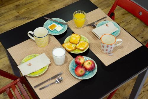 a table with plates of fruit and glasses of orange juice at Hostel Bulwark in Valença