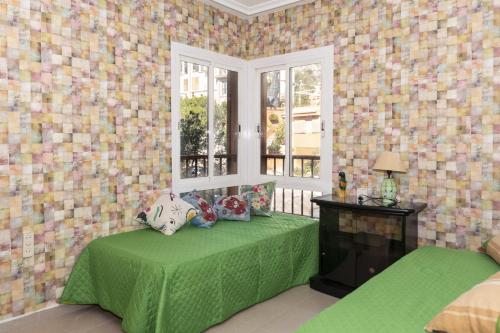 a bedroom with a green bed and a window at Nueva Vista 2º-4 in Cullera