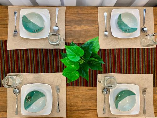 una tavola con piatti e argenteria su un tavolo di BRAND NEW Cosy Minimalist Home a Butterworth