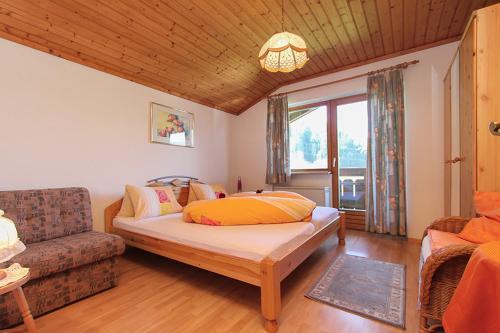 uma sala de estar com uma cama e um sofá em Ferienwohnung Schwalbenwandblick em Saalfelden am Steinernen Meer