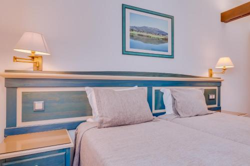 a bedroom with two beds and a blue headboard at Hotel Mar A Vista in Albufeira