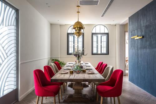 台東市的住宿－太太的小公館 民宿 僅限 13 歲以上旅客入住，一间带桌子和红色椅子的用餐室