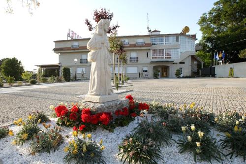 a statue in the middle of a street with flowers at Hotel A Queimada in Nigrán