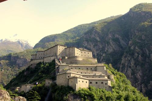 a large castle on a hill with mountains at Belvedere Di Simona Cotti Piccinelli in Bard