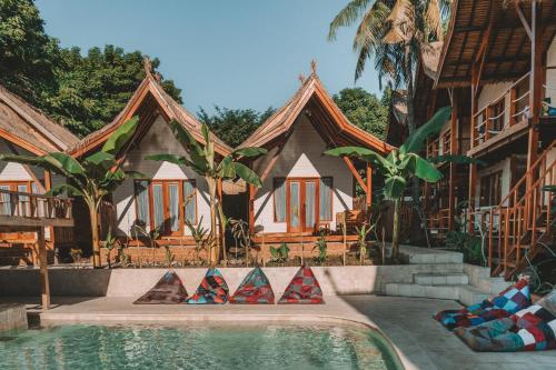 ein Haus mit einem Pool vor einem Haus in der Unterkunft Voodoo Gili in Gili Trawangan