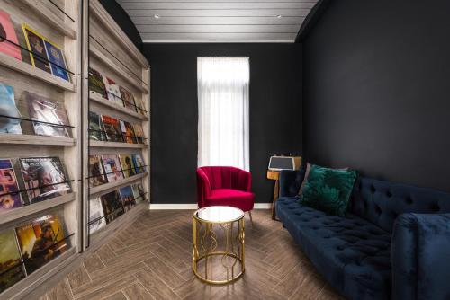 a living room with a blue couch and a red chair at 太太的小公館 入住須滿13歲以上 in Taitung City