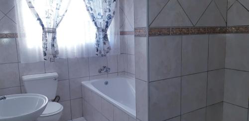 y baño con aseo, bañera y lavamanos. en Getaway Self-Catering Tyger Valley, en Durbanville