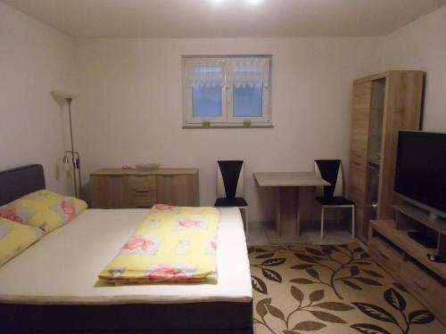a bedroom with a bed and a flat screen tv at Ferienwohnung Keil in Lahr