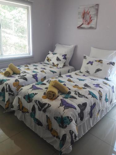 a bedroom with two beds with butterflies on it at 15 Isikhulu in Umdloti