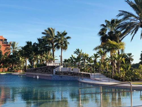 a pool at a resort with palm trees at Playa Granada Apartamentos Moriscos II in Motril